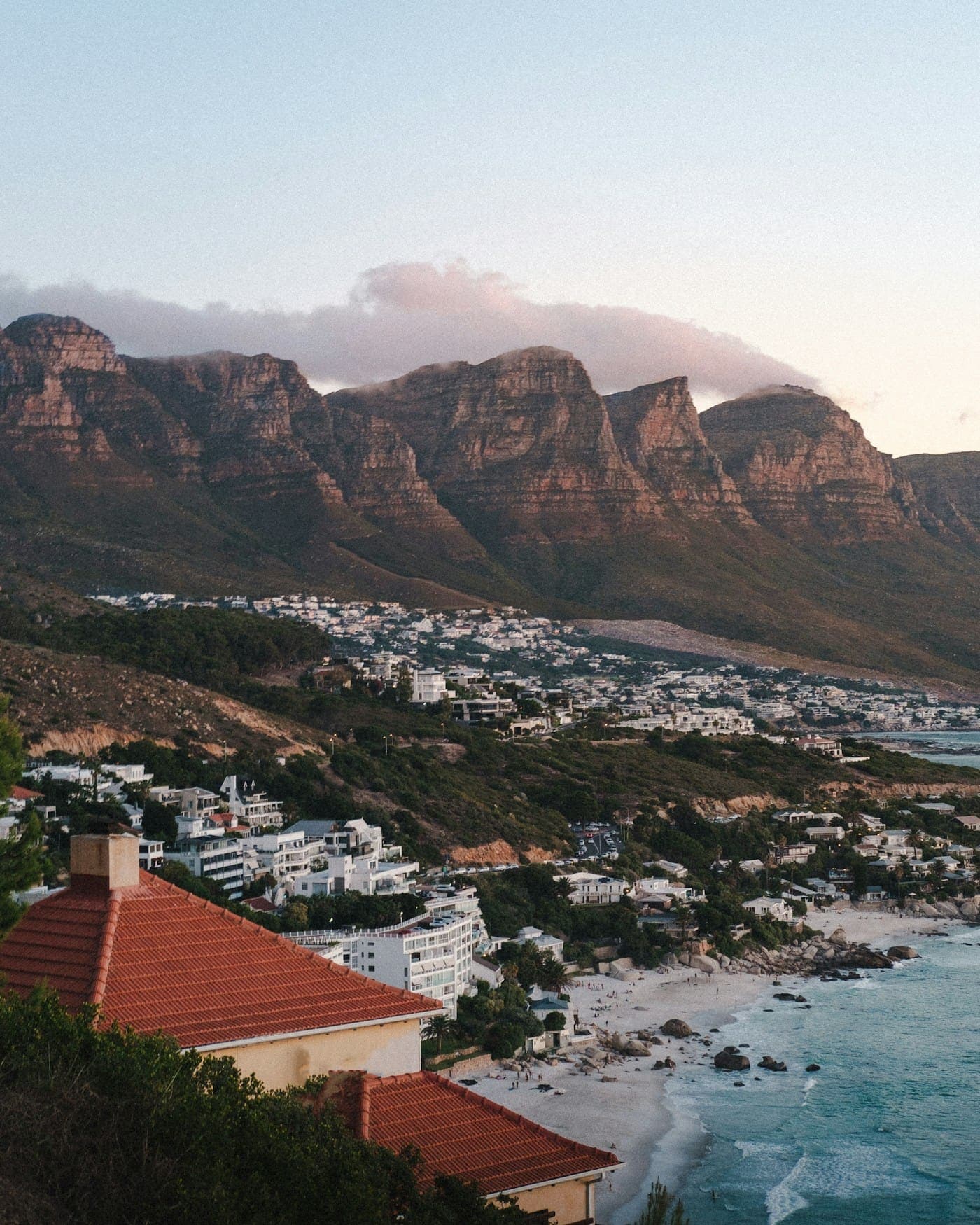 Houses of Camps Bay under the Twelve Apostles mountains at dusk